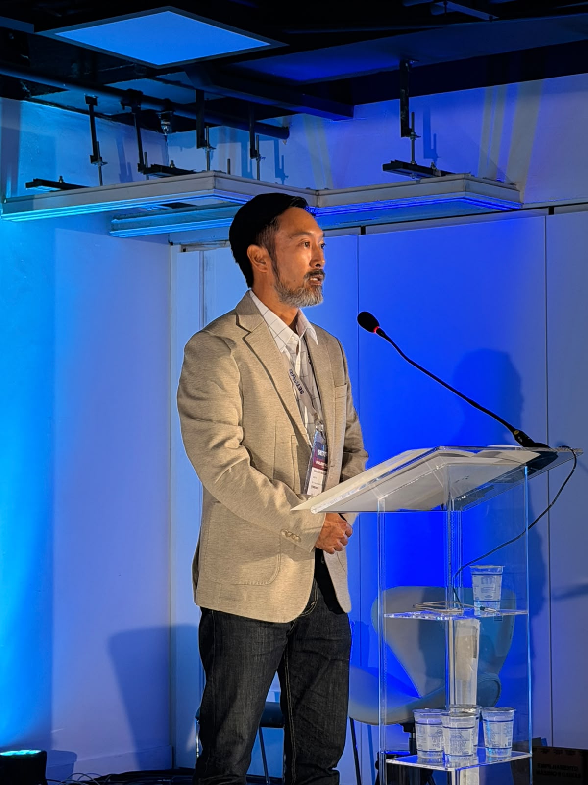 Marcus Imaizumi falando em um evento profissional